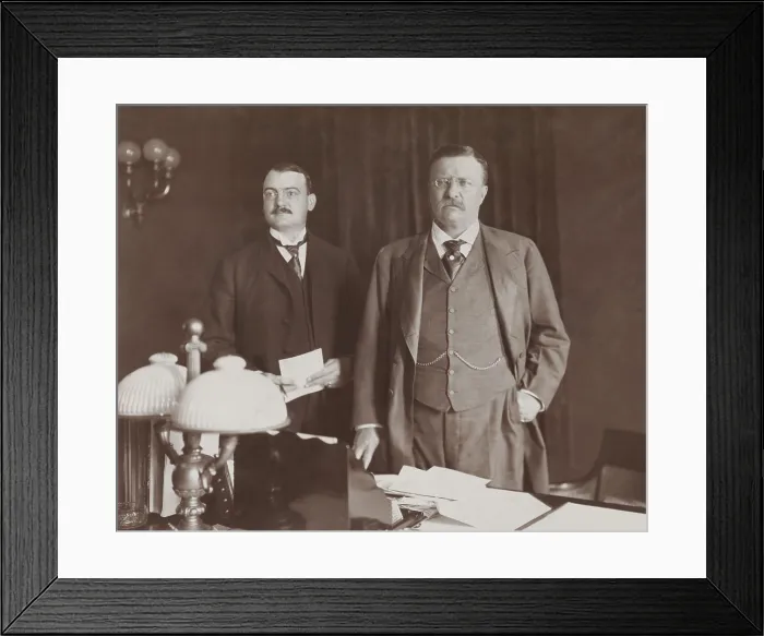 Framed Print : Theodore Roosevelt standing behind desk, with Asst. Presidential Secretary William Loeb, 1902. At that time, George B