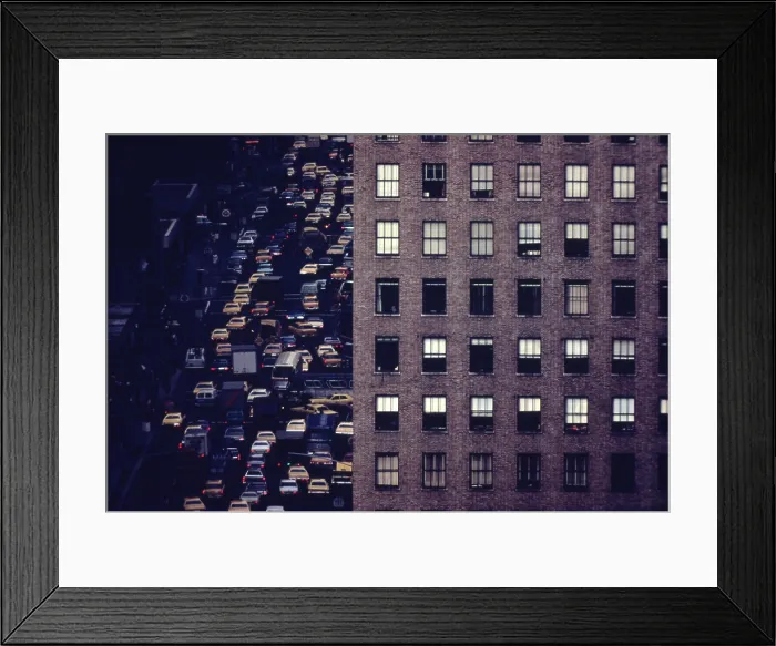 Framed Print : Traffic in New York City. View of vehicles on Manhattan's Sixth Avenue at 42nd Street is framed by a massive pre-war apartment building. Ca. 1973-75