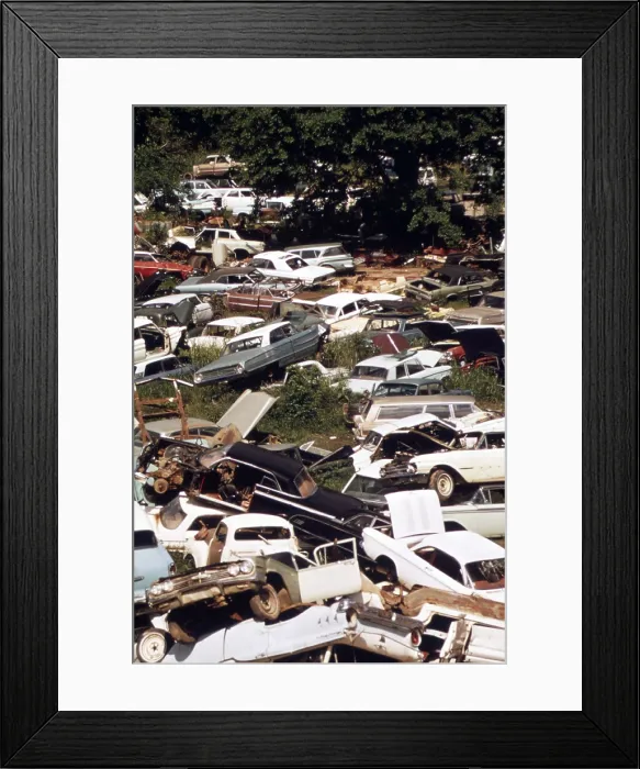 Framed Print : An automobile junkyard. Wrecked car parts were sold for auto repairs and whole cars for recycling as scrap steel. Ca. 1973-75