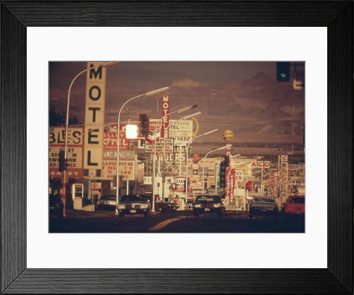 Framed Print : Las Vegas commercial street is a landscape of signs the a desert and mountain backdrop. Ca. 1972-75