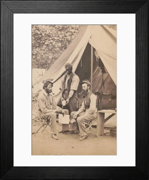Framed Print : Two Union Civil War soldiers seated in front of tent, as African American contraband servant pours them a drink. The contraband would be working for wages or other compensation Framed Print : Two Union Civil War soldiers seated in front of tent, as African American contraband servant pours them a drink. The contraband would be working for wages or other compensation