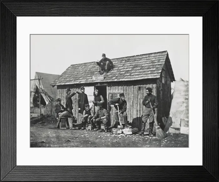 Framed Print : US Civil War, 1863. Pine Cottage, a hut built in Union soldiers winter quarters. Nine men, pose sitting or doing some work