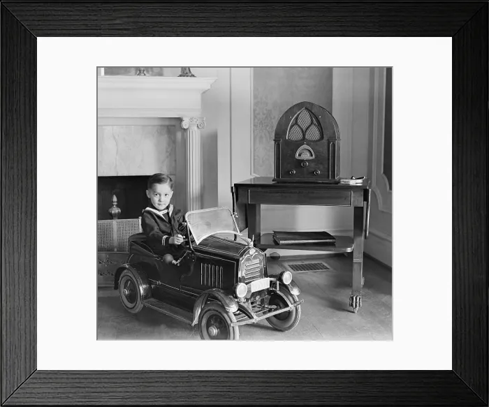 Framed Print : Little boy in his toy automobile next to a state of the art Atwater Kent Radio