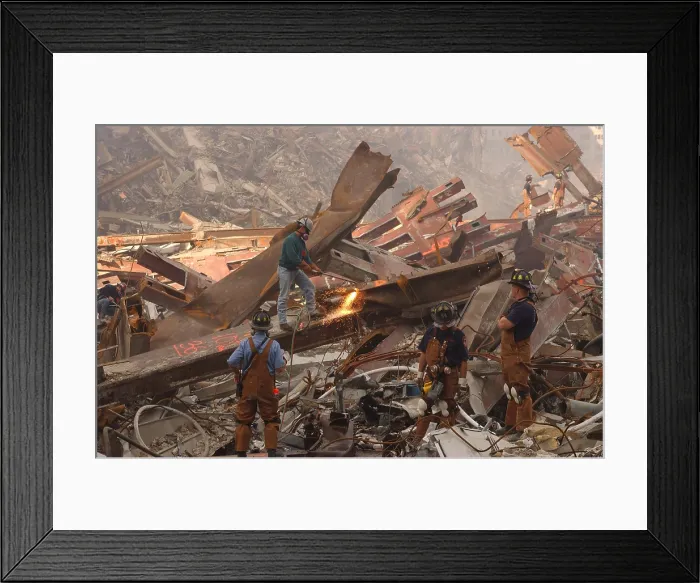 Framed Print : Dwarfed by the debris from the World Trade Center metal workers cut though the rubble pile in a futile search for survivors a week after the attacks, September 19, 2001