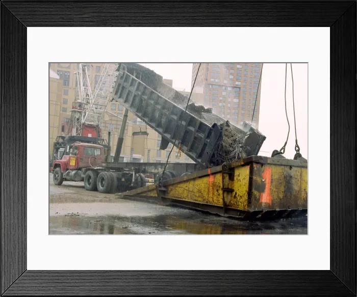 Framed Print : A few blocks from Ground Zero a truck dumps World Trade Center debris into the bucket of a 500-ton crane at a Hudson River loading Framed Print : A few blocks from Ground Zero a truck dumps World Trade Center debris into the bucket of a 500-ton crane at a Hudson River loading