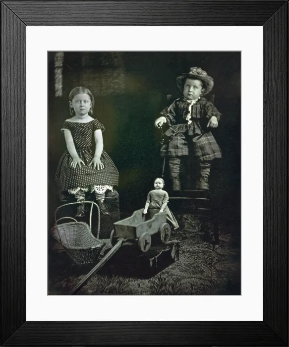 Framed Print : Two Children with Toys, ca. 1855, by an unidentified photographer. A girl and boy pose with their handcrafted toys: a doll, wagon and basket cradle (BSLOC_2019_8_161)
