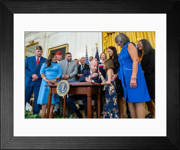 Framed Print : President Joe Biden hands the pen to Brielle Robinson after signing the Sergeant First-Class Heath Robinson Honoring our Promises to Address Comprehensive Toxics (PACT)