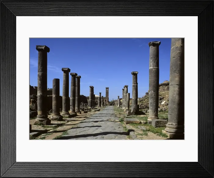 Framed Print : Columned Way, 2nd Century a.C. basalt - Syria, Bosra. Whole view. Overall view of the columned paved Via with capitals and pedestals