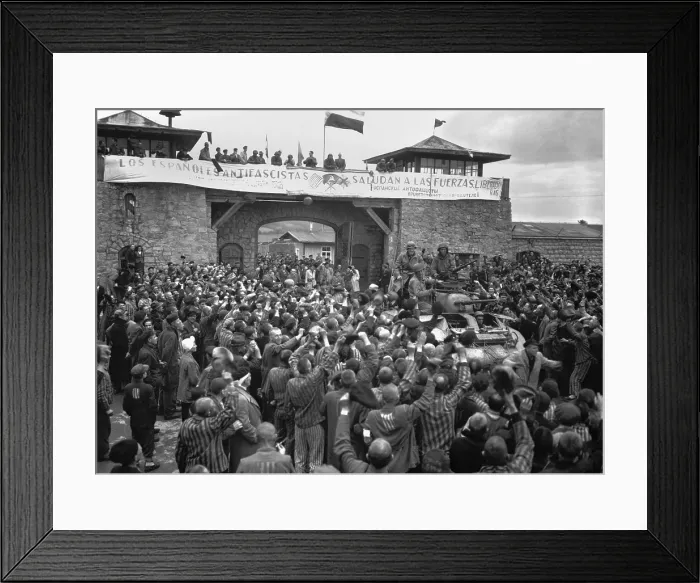Framed Print : Liberated prisoners in the Mauthausen concentration camp cheer U.S. soldiers. The banner across the wall was made by Spanish Loyalist prisoners. The U.S