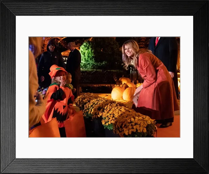 Framed Print : First Lady Melania Trump poses for a photo with a trick-or-treater during the 2020 White House Halloween celebration, Oct. 25, 2020, at the South Portico (BSLOC_2020_9_16)