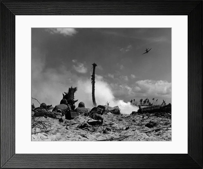 Framed Print : U.S. Marines in the sand shoot across No Man's Land with rifle fire. American fighter flies overhead to strafe the Japanese hidden in their coral trenches