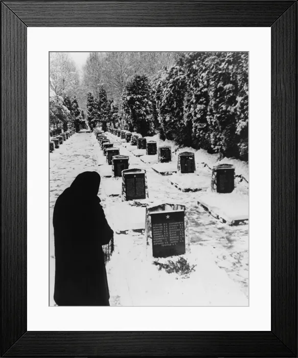 Framed Print : Russian woman in a snow-covered military cemetery. World War 2 Soviet tombstones are inscribed with several names. Unknown location. 1945 photo by Yevgeny Khaldei