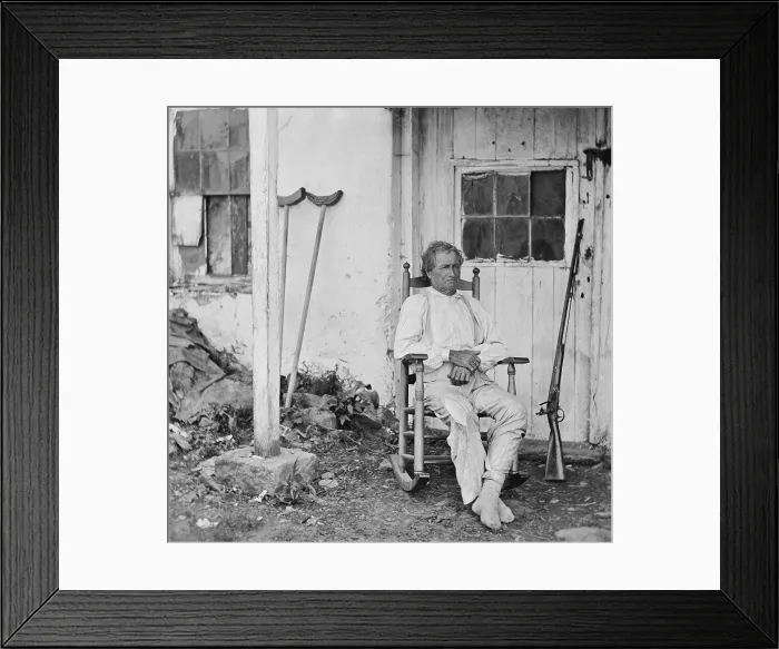 Framed Print : John L. Burns, the old hero of Gettysburg, sits in a rocking chair with his gun and crutches nearby Framed Print : John L. Burns, the old hero of Gettysburg, sits in a rocking chair with his gun and crutches nearby