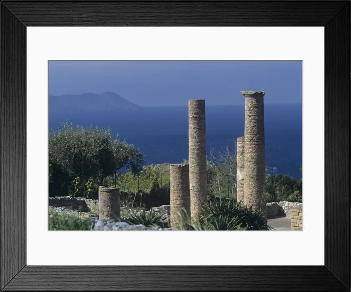 Framed Print : Insula Domina, 1st and 4th Century b.C. - Italy, Sicily, Patti, Tindari. Detail. Some coloumnswith the island of Vulcano in the background