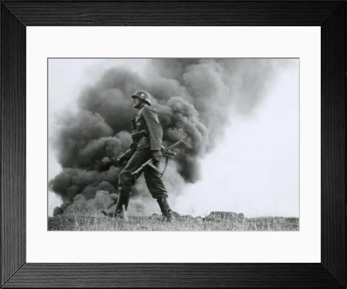 Framed Print : German officer of assault troops during the Nazi invasion of the Soviet Union, (Russia) In the Summer of 1941, the soldier strides against a background of burning buildings