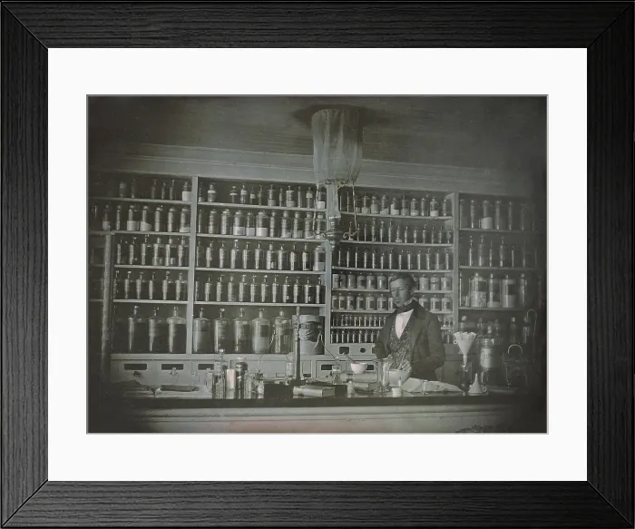 Framed Print : Pharmacist posing in his business, the S. P. Peck Apothecary, possibly in Bennington, Vermont. The photo was likely taken between 1845-1860, by an itinerant daguerreotypist
