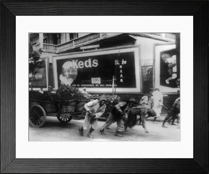 Framed Print : Chinese men pulling cart along a city street in China, c. 1927. Behind them is a billboard advertising Keds sneakers (BSLOC_2016_8_28) Framed Print : Chinese men pulling cart along a city street in China, c. 1927. Behind them is a billboard advertising Keds sneakers (BSLOC_2016_8_28)