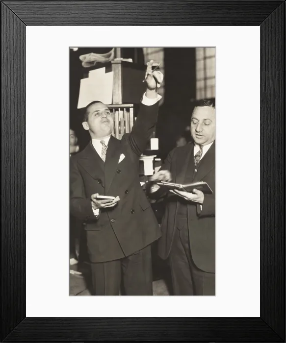 Framed Print : Two brokers at New York Curb Exchange Building in 1929. One is signaling with his hands as another leafs through a notebook