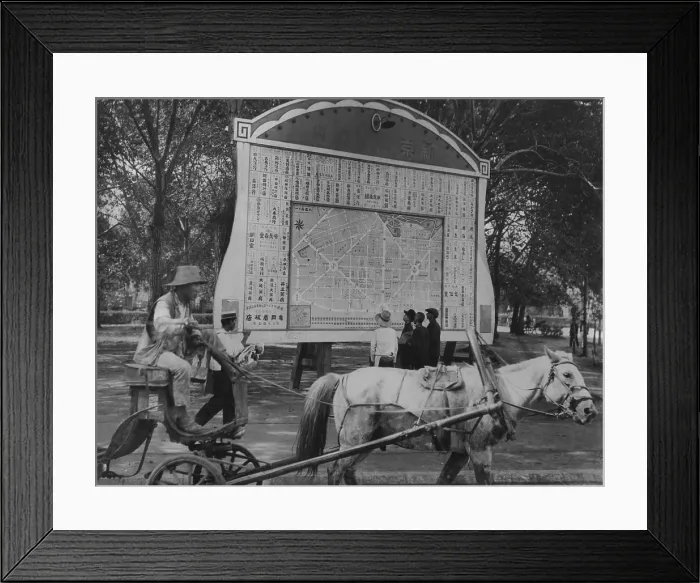 Framed Print : Horse drawn wagon passes billboard with Japanese plan for new city of Hsinking, Manchukuo