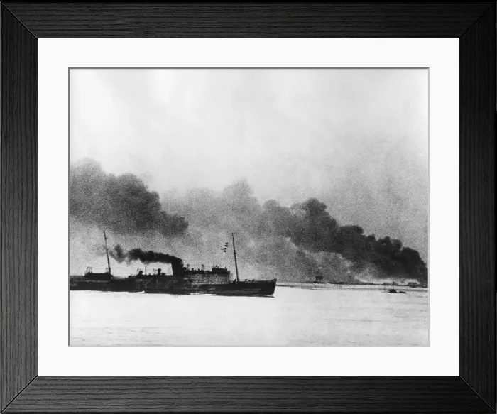 Framed Print : Ship leaving Dunkirk carrying defeated British and French soldiers to England. In the background the French port of Dunkirk burns under the German advance. World War 2