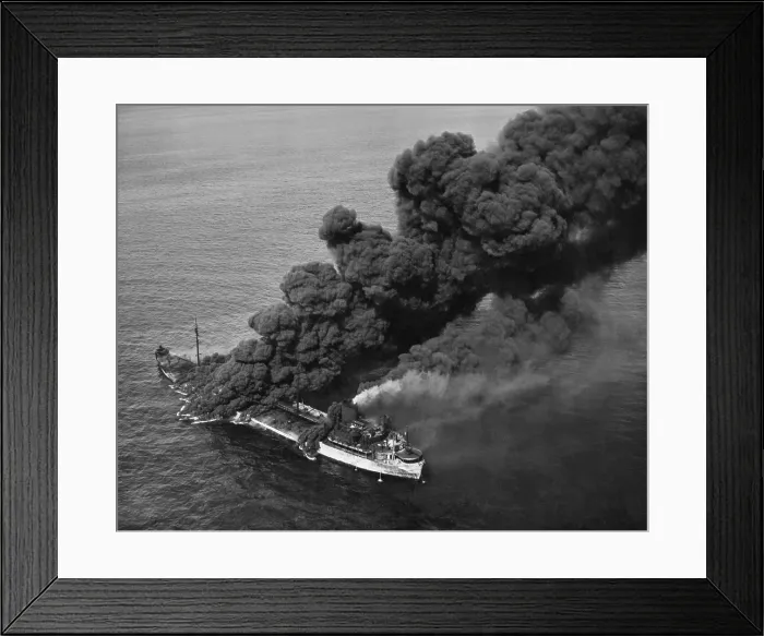 Framed Print : A torpedoed American tanker burning after an Axis submarine attack. Crew members brought the fire under control and the ship was towed to port for repair. Ca. 1942-43