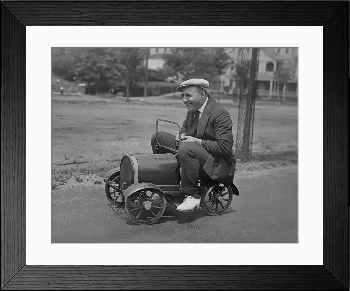 Framed Print : Man seated on a child's toy car in a street. New York City vicinity, 1920s (BSLOC_2016_10_133)