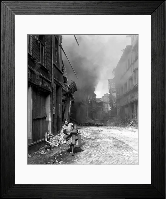 Framed Print : German woman runs from burning building carrying a suitcase and a few rugs. The fire was started in by Nazi saboteur in Seigburg, Germany, during the last month of World War 2