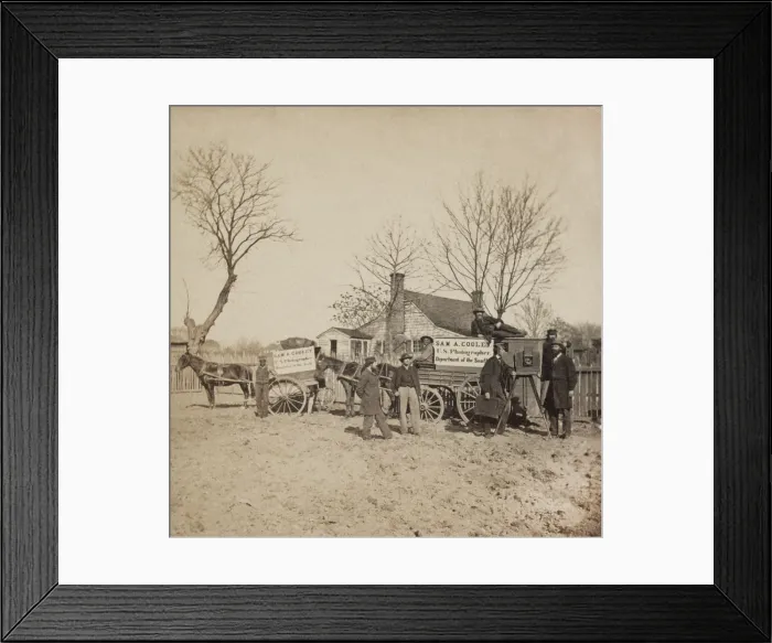 Framed Print : A group of men stand next to wagons labeled Sam A. Cooley U.S. Photographer Department of the South. There is a camera on the left, and two African American drivers