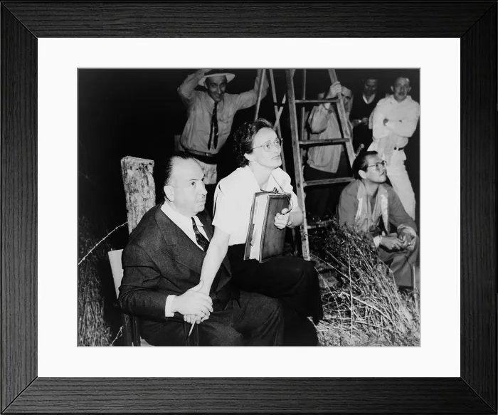 Framed Print : Alfred Hitchcock, seated with Adele Cannon on set of Spellbound'. Cinematographer George Barnes is in the background. 1946. - (BSLOC_2014_17_80)