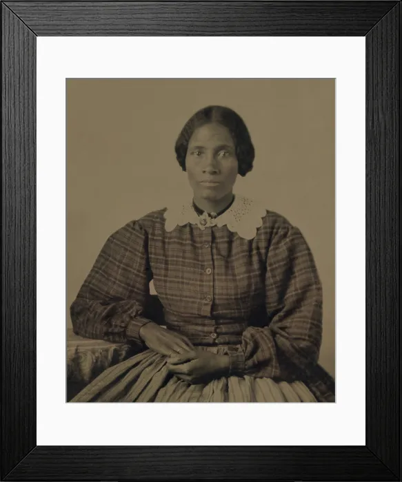 Framed Print : Fashionable dressed, pretty, African American woman of the 1860s. The ambrotype show her gracefully posed, wearing a plaid dress with full long sleeves and a lace collar