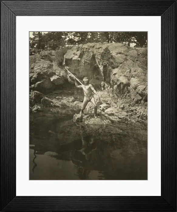 Framed Print : Lummi man aiming his spear at a salmon in the Puget Sound area. 1924 photo by Fred H. Kiser