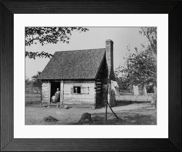 Framed Print : African American woman seated in log cabin doorway, which possibly once housed slaves, ca. 1890 (BSLOC_2020_2_96) Framed Print : African American woman seated in log cabin doorway, which possibly once housed slaves, ca. 1890 (BSLOC_2020_2_96)