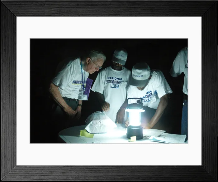 Framed Print : Former President Jimmy Carter observes poll closing by lantern-light in Monrovia during Liberias 2005 national elections