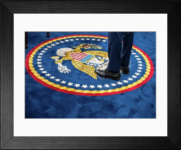 Framed Print : A quixotic portrait of President Joe Biden, including only his lower legs and shoes on the presidential seal of the Oval Office carpet, August 29, 2023. (BSLOC_2023_8_5)