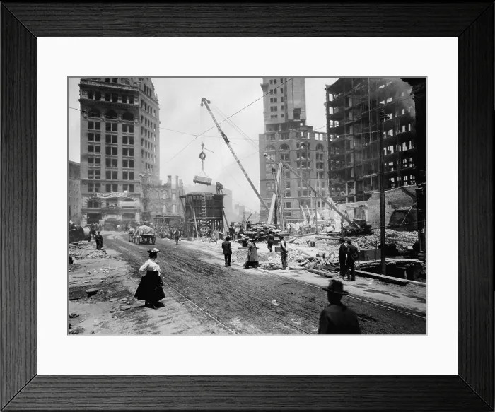 Framed Print : San Francisco rebuilding after the April 18, 1906 earthquake and fire. A crane is moving rubble, as several men and a woman walk by in 1906 (BSLOC_2017_17_52)