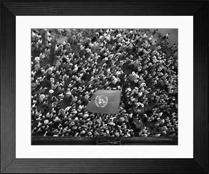 Framed Print : United Nations flag waves over crowd waiting to hear Dr. Syngman Rhee speak to the United Nations Council in Taegu, Korea