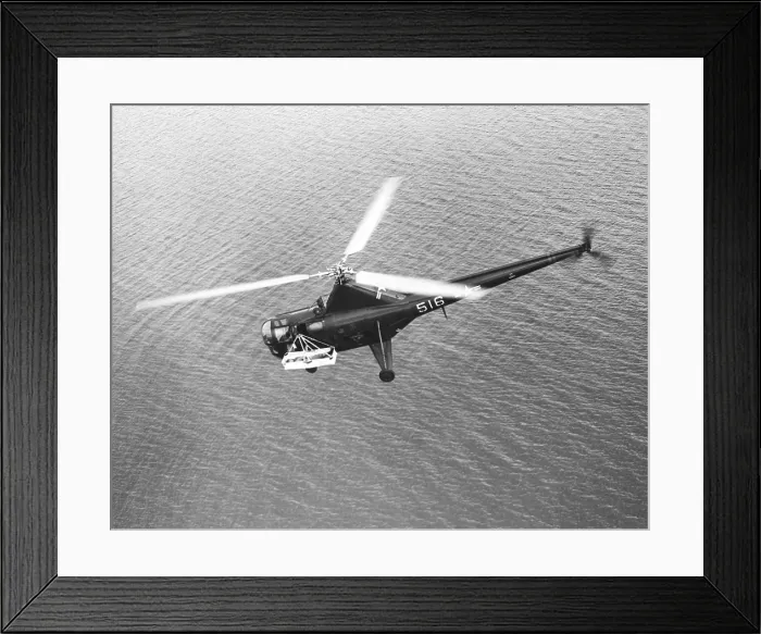 Framed Print : U.S. H-5G helicopter's flying over water with a patient in an outboard litter during the Korean War. Ca. 1950-53. (BSLOC_2014_11_196)