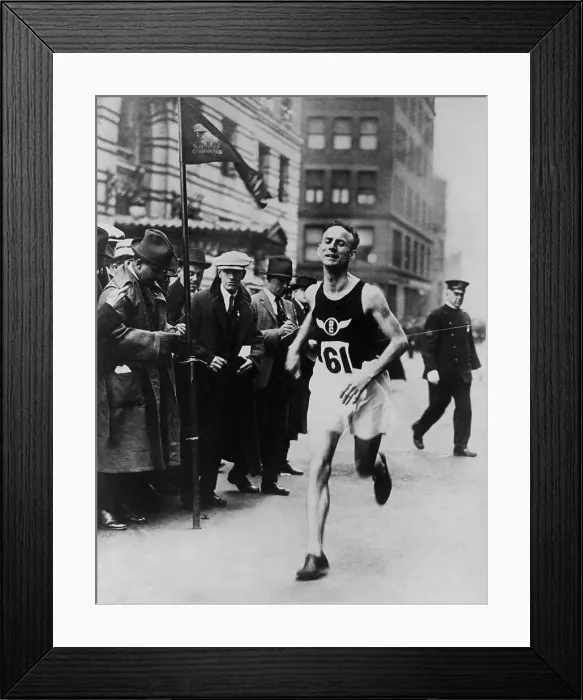 Framed Print : Clarence Demar, running through an urban city commercial district. He crosses the finish line, as reporters take notes at left, ca. 1924 (BSLOC_2020_2_203)