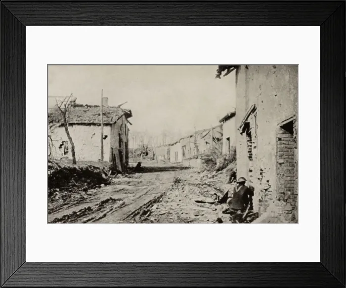 Framed Print : World War 1. American soldier in the a shattered French town, taking cover from a concealed German machine-gun nest in the woods beyond the end of the street. Ca