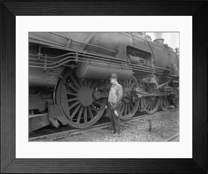Framed Print : Mechanic servicing a railway steam engine in 1924. Massive locomotives has increased speed and power to move heavier loads (BSLOC_2016_10_178)