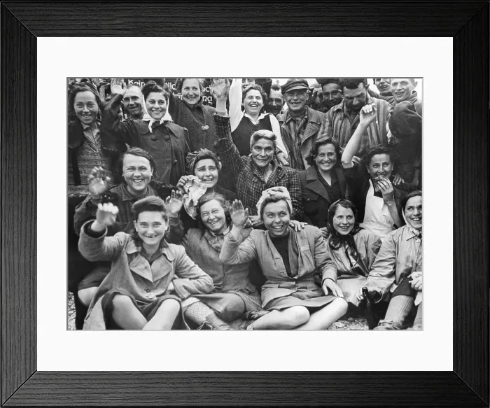 Framed Print : Liberated women prisoners at Dachau Concentration Camp wave and cheer for a group portrait. Photo was taken by U.S. Signal Corps Photographer, ca