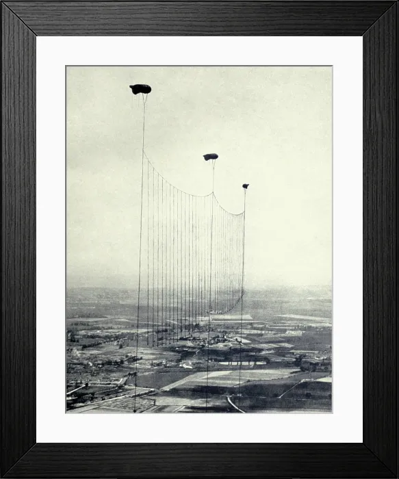 Framed Print : World War 1. British Barrage balloons dangle metal cables, to disable low-level German aircraft on night bombing missions over England. 1915-18. (BSLOC_2013_1_83)
