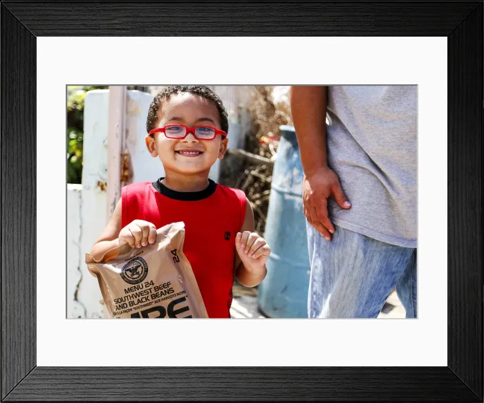 Framed Print : A little boy with army rations distributed in San Juan, Puerto Rico, after Hurricane Maria. The storm struck the island on Sept Framed Print : A little boy with army rations distributed in San Juan, Puerto Rico, after Hurricane Maria. The storm struck the island on Sept