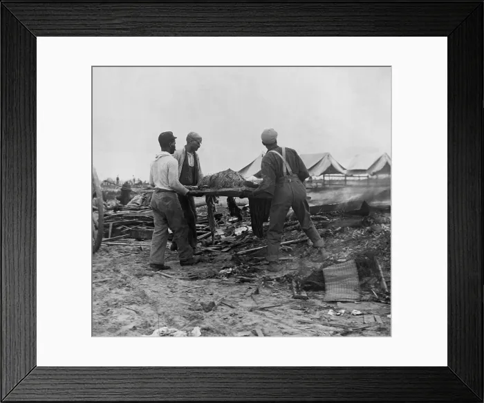 Framed Print : African American men carrying a body on stretcher to a fire (at right) to be cremated. Initial burials at sea caused bodies to be washed back to the Texas coast. Sept