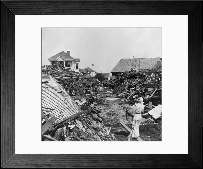Framed Print : A woman walks through a passageway opened in the debris, on 19th Street, Galveston, Texas