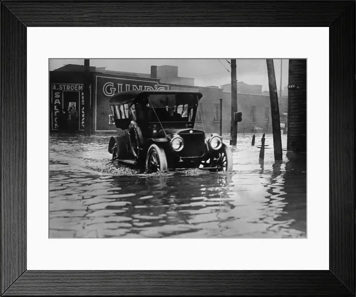 Framed Print : An automobile drives through axel high water on a flooded Cleveland street, probably in 1913