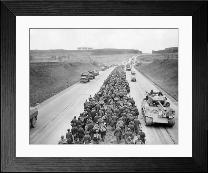 Framed Print : Thousands of German prisoners march along the Autobahn near Giesson, northwest of Frankfurt. In the opposite direction American tanks and vehicles advance to the battlefront