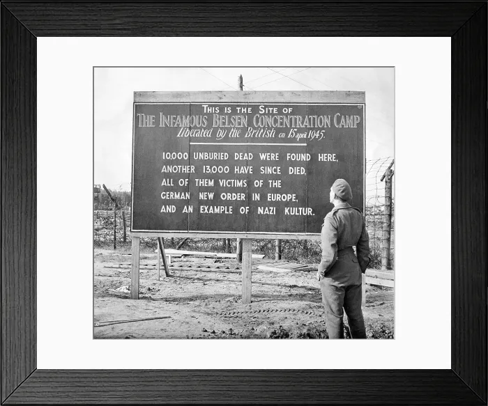 Framed Print : British soldier stands by a sign posted at the site of the Belsen Concentration Camp, 1945