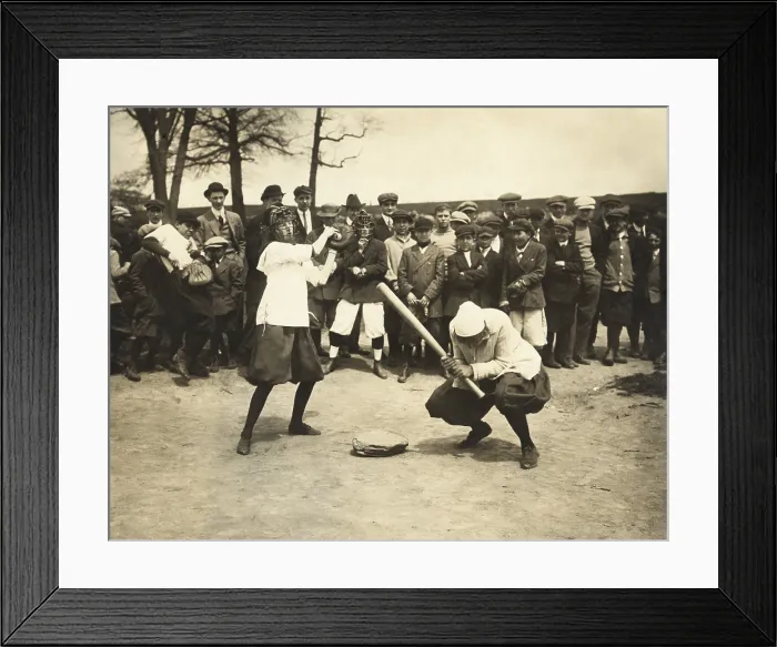 Framed Print : Young woman baseball player ducks, while female behind her has caught the wild pitch in her glove