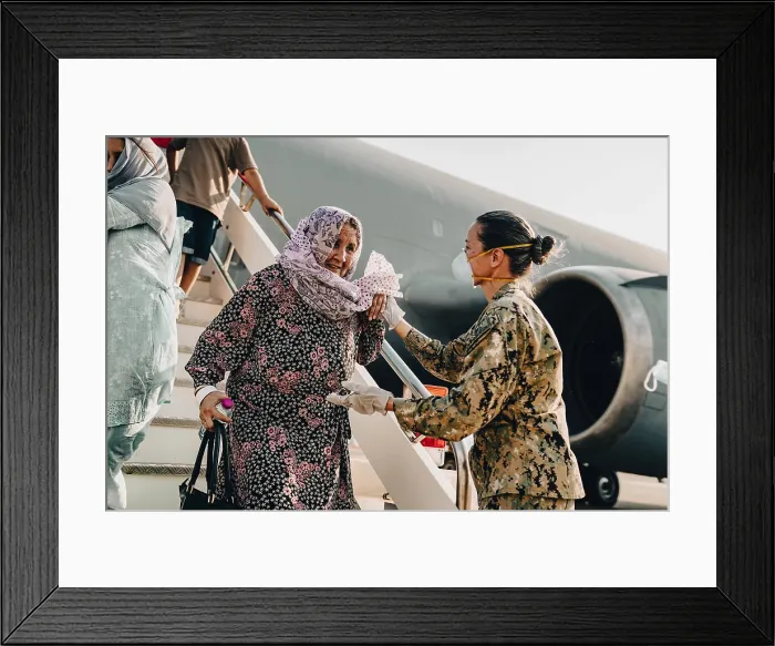 Framed Print : US Navy Master Chief Anna Wood assists an Afghan evacuee upon arrival at the Italian Air Force Base, in Sigonelle, Sicily (BSLOC_2021_14_46)